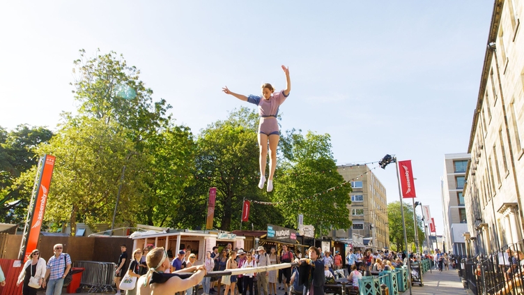 Street performers flyering on the Royal Mile in front of large crowd
