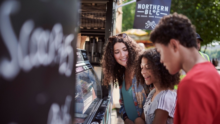 Amigos comprando helados en un puesto