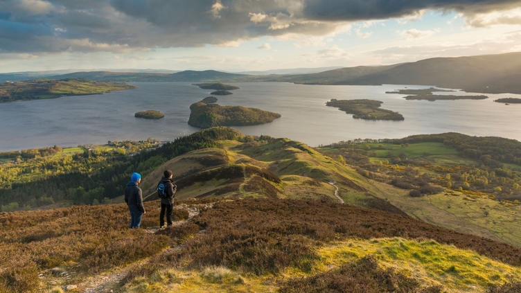 Caminantes contemplando las vistas de Loch Lomond desde Conic Hill, parte de la ruta West Highland Way
