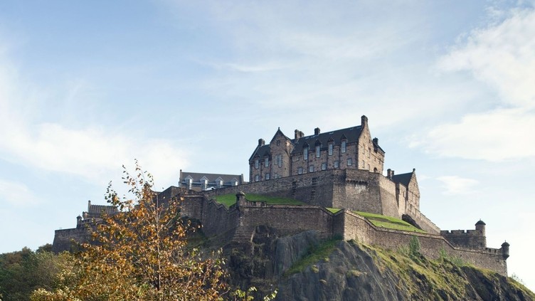 Family with children in gardens with a view up to a castle