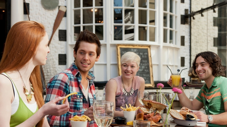 Un grupo de personas en un restaurante de Brighton, comiendo al aire libre en el restaurante Fishy Fishy