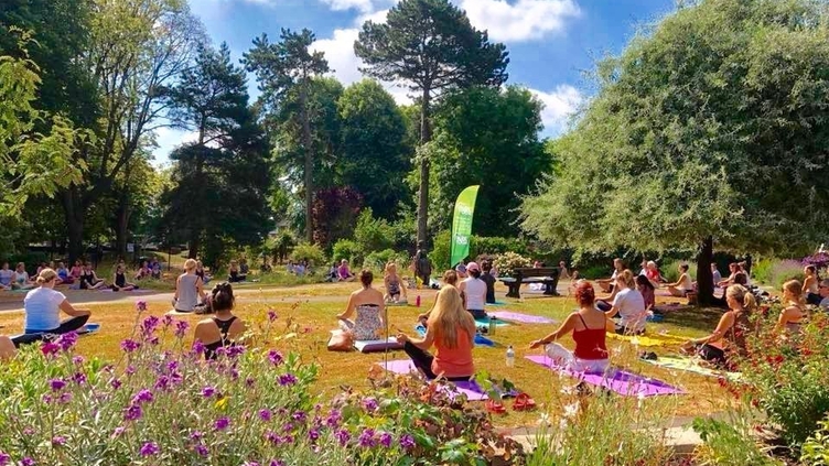 Groups of people taking a yoga session in a park on the Jurassic Coast