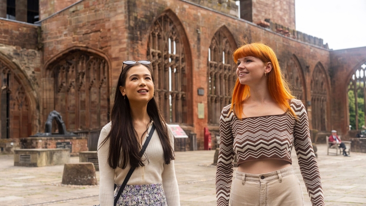 Two women explore the ruins within the grounds of a Cathedral