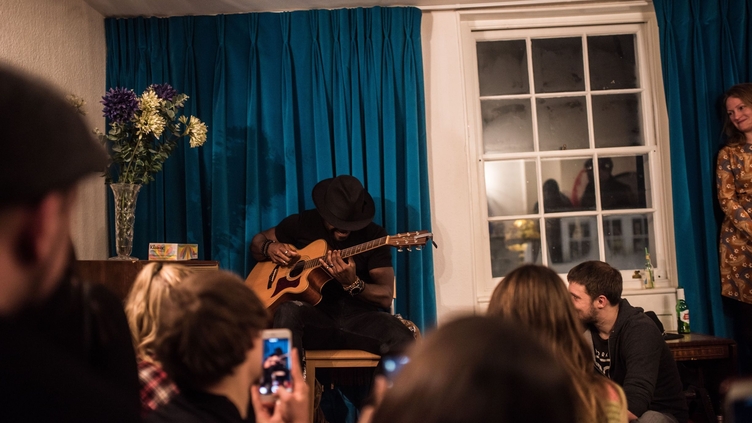 Ein Mann spielt Gitarre vor Publikum im Handel and Hendrix