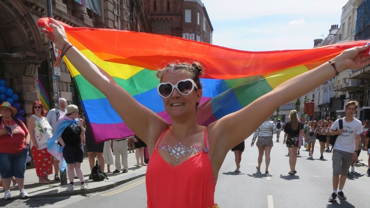 Woman flying rainbow flag during Pride