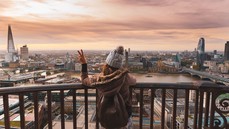 Woman at the top of St Paul's dome at sunrise with city view