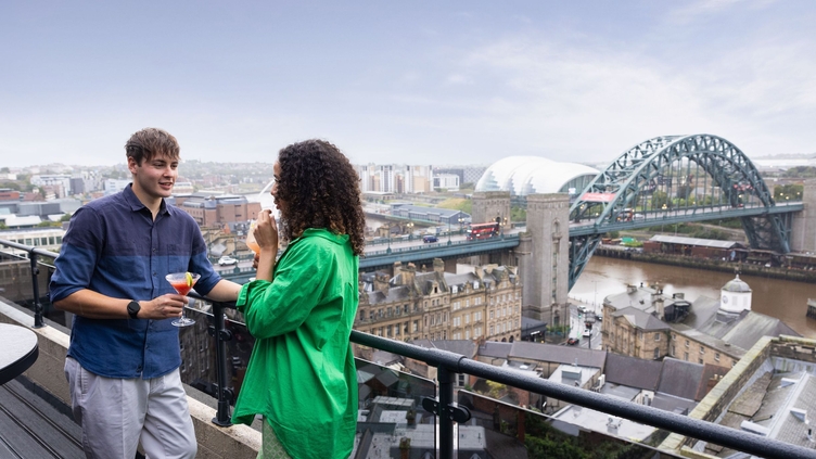 Two friends enjoy a cocktail at Above, a bar overlooking Newcastle upon Tyne city centre.