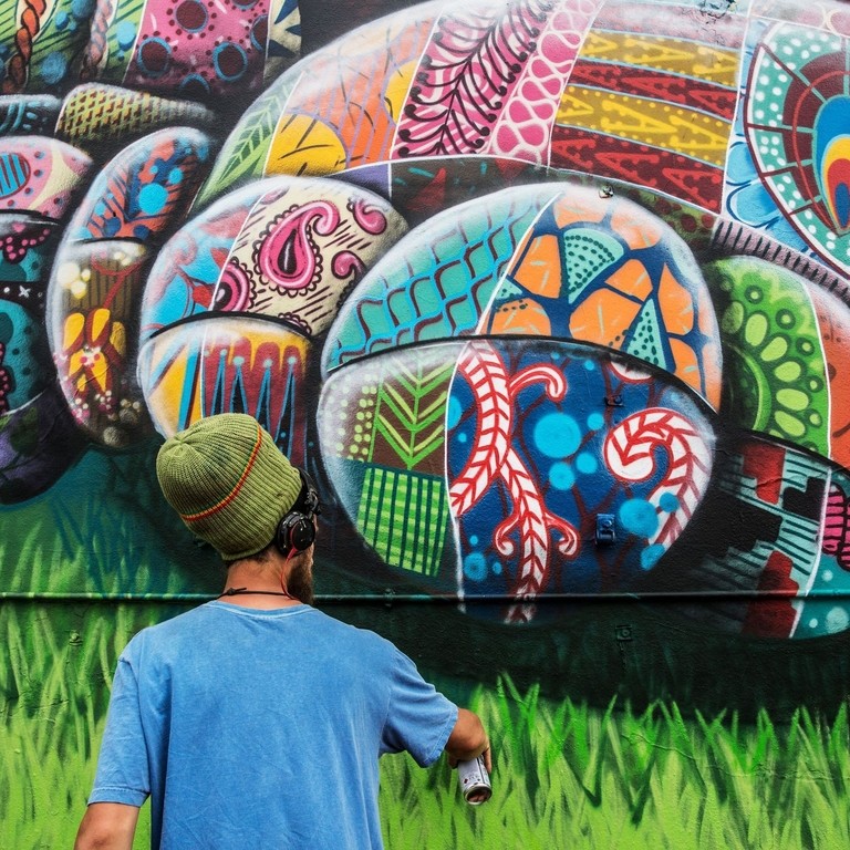 An artist with a can working on artwork. Cartoon design