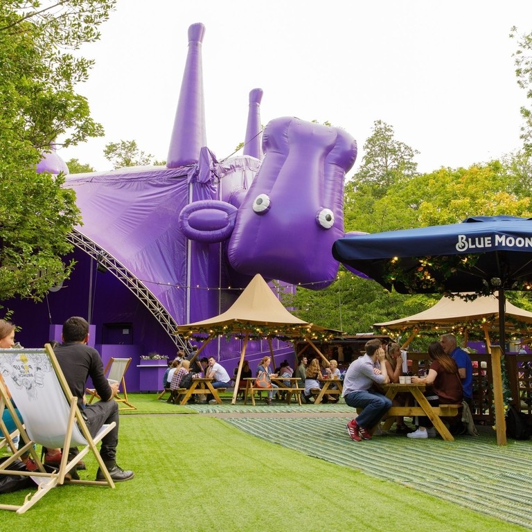Visitors relaxing outside the purple cow and performance tent in George Square.