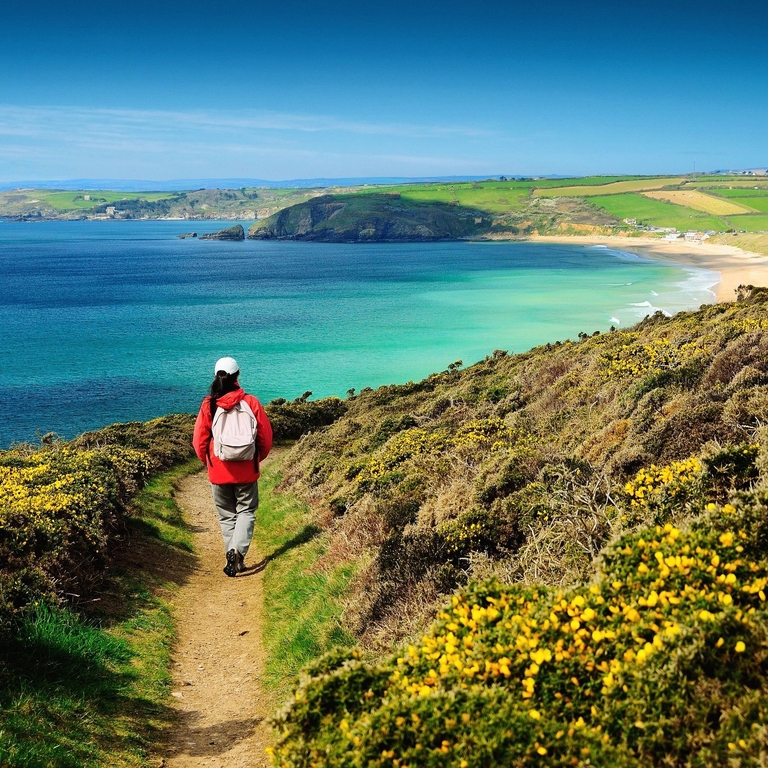 A person on a footpath on the coastal path near sea