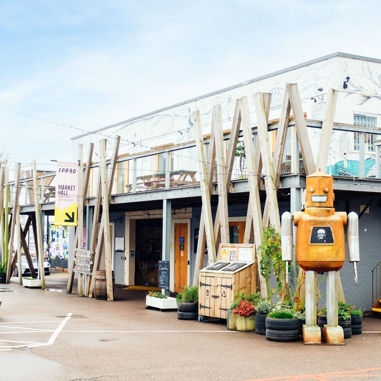 Robot sculpture outside a building with geometric décor